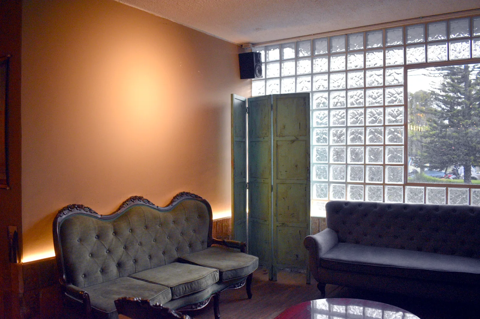 Sofás verdes junto a la ventana en la Sala Tertulia